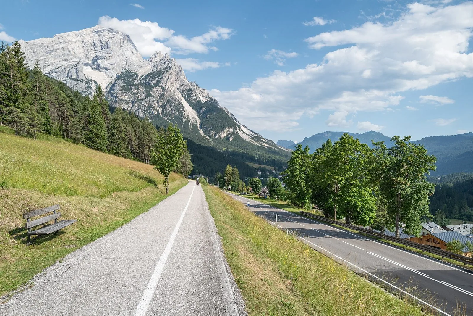 La pista ciclabile della Lunga Via delle Dolomiti a San Vito di Cadore, con una panchina e le montagne sullo sfondo